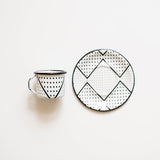 Black and white patterned expresso mug and plate on a light beige background