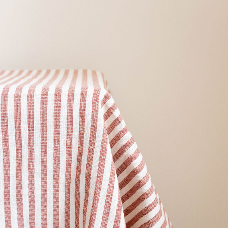 cinnamon and beige striped tablecloth on a plain background