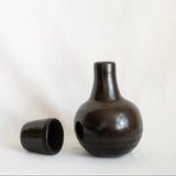 Black ceramic vase with textured surface on a white background