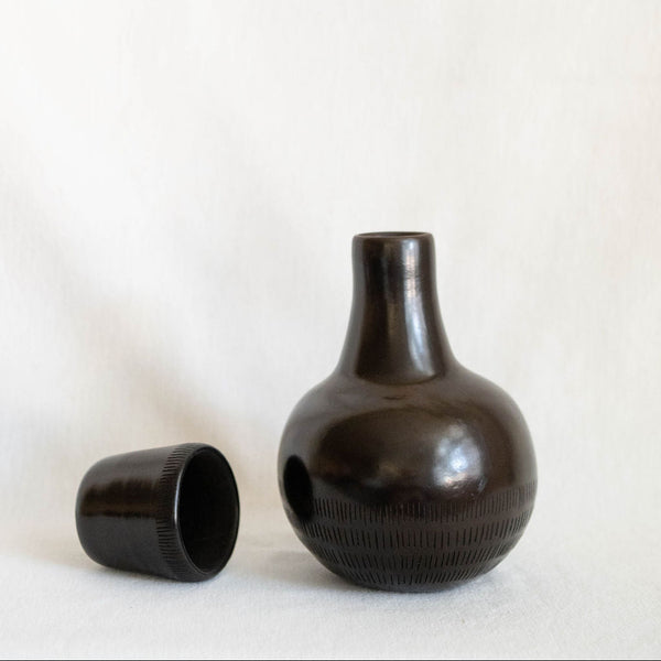 Black ceramic vase with textured surface on a white background