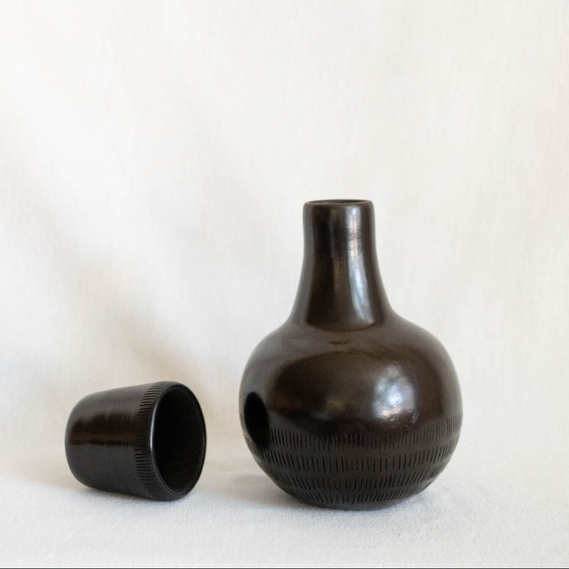 Black ceramic vase with textured surface on a white background
