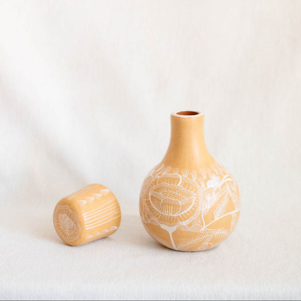 Small ceramic vase with textured design on a plain background