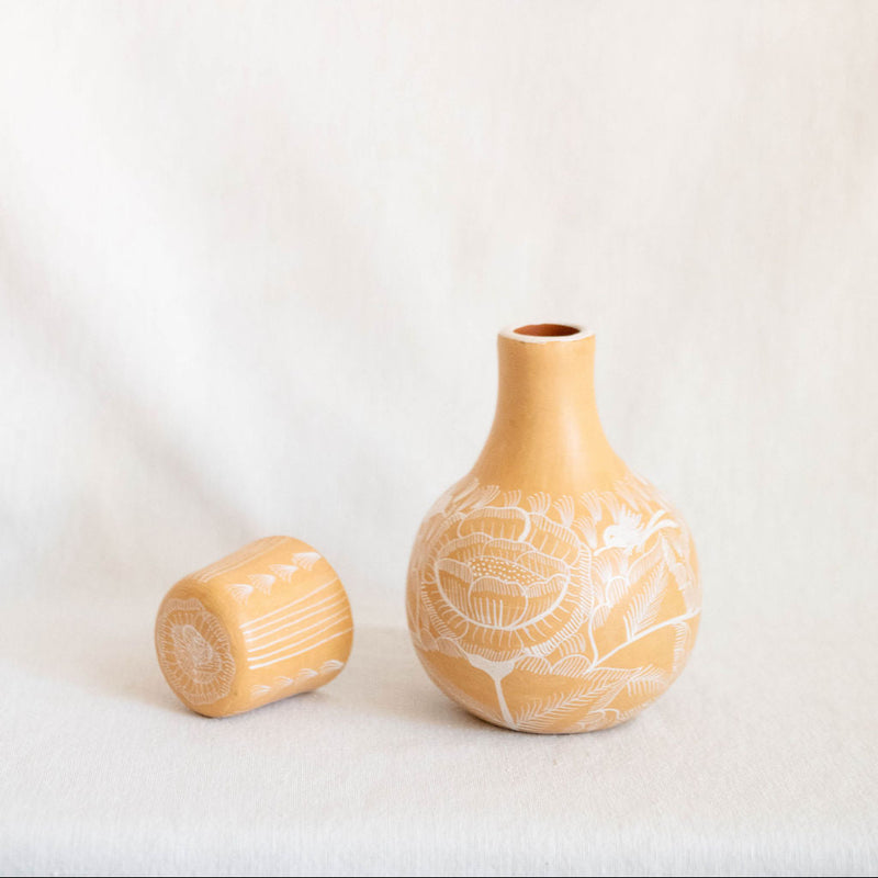 Small ceramic vase with textured design on a plain background