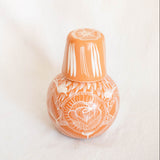 Decorative vase with white floral patterns on a light beige background