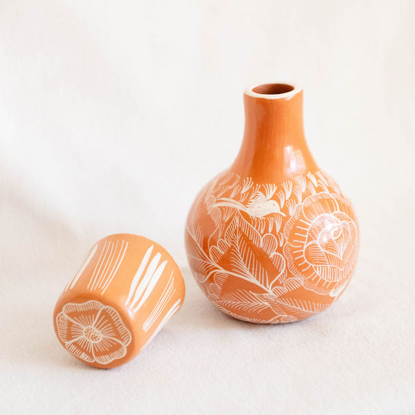 orange ceramic vases with white floral patterns on a light beige background