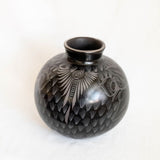 Black ceramic vase with white patterns on a white background