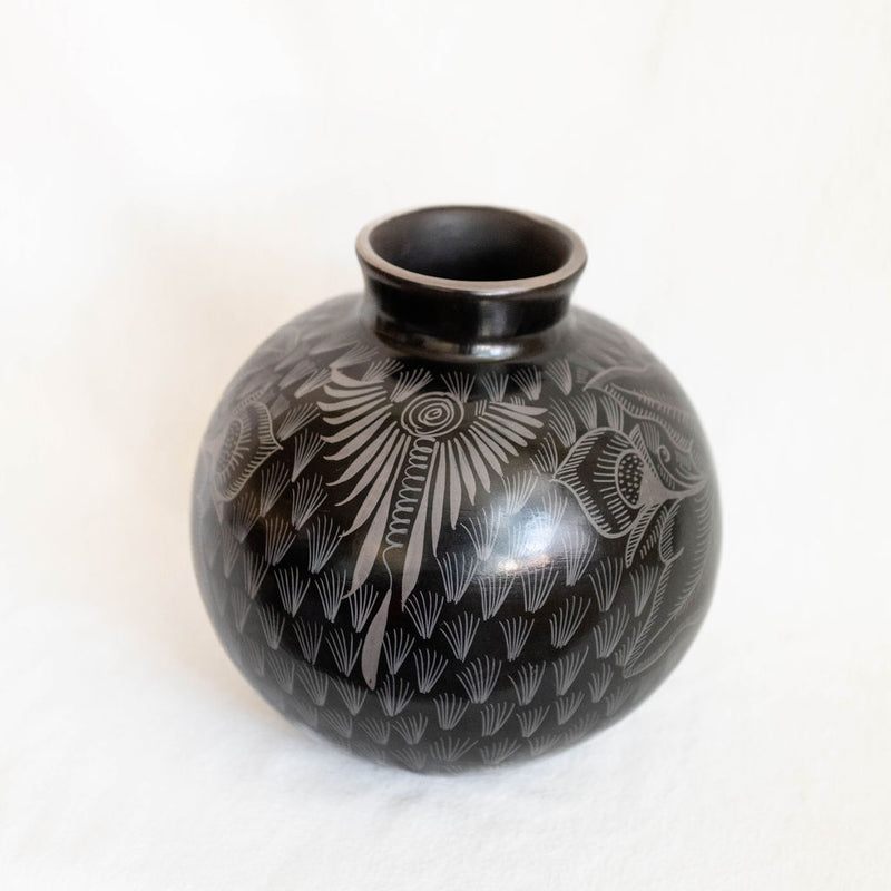 Black ceramic vase with white patterns on a white background