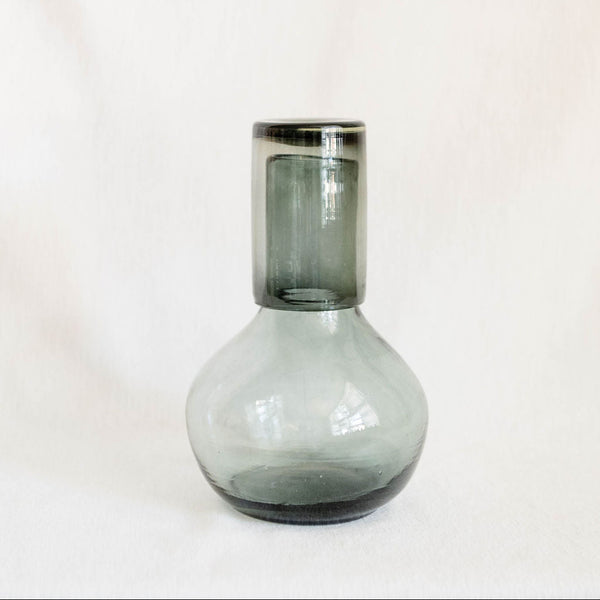 Clear Black recycled glass carafe with cup as a lid on a white background