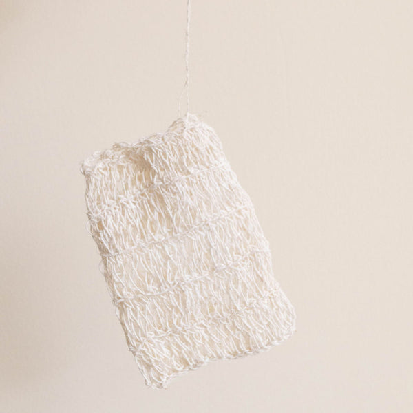 Agave fiber soap bag with drawstring on a beige background
