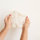 Hands holding an agave ayate washcloth  against a plain background