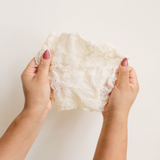 ayate agave plastic-free washcloth held up by two hands showing how it exfoliates and cleanses