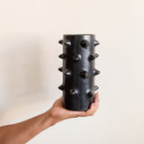 Hand holding a handcrafted black Spiked Mexican Ceramic Clay Vase, featuring a bold, modern spiked design. Perfect for contemporary home decor or as a unique artisanal statement piece.