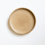 Ceramic Saucer in beige / tan color with sleek finish and subtle speckling on white surface