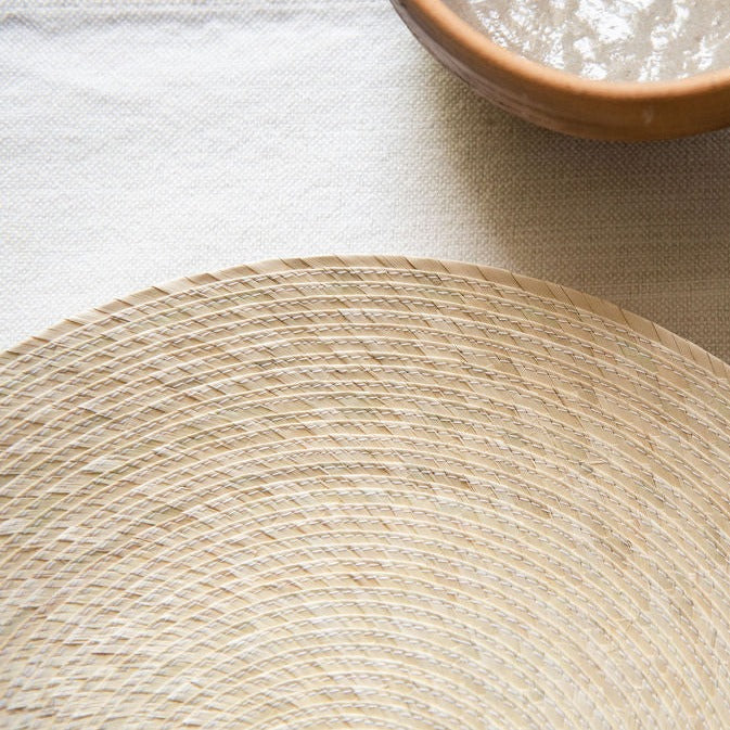 Closeup of a natural, round palm placemat woven and sown