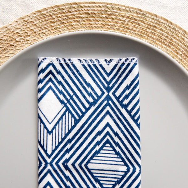 Cotton flannel napkin in blue aztec stripes laying flat on a plate